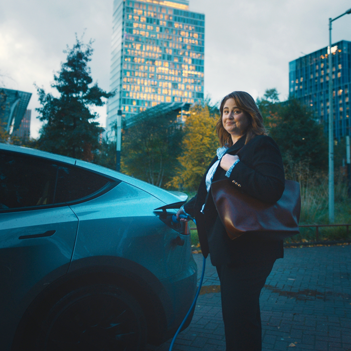 Vrouw bij elektrische deelauto Campagne Ministerie Infrastructuur en Waterstaat Start met delen