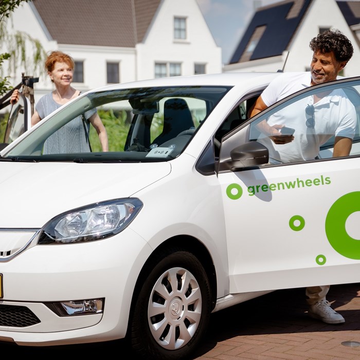 Ouder koppel stapt in Greenwheels elektrische deelauto voor zomerse rit