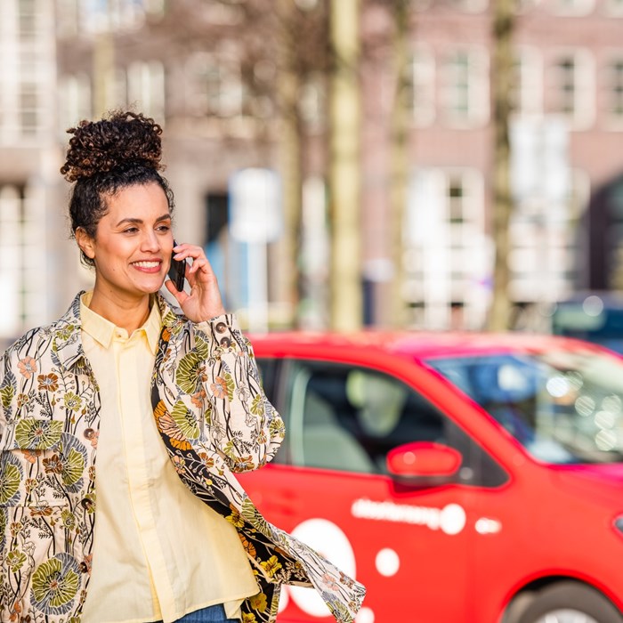 Vrouw belt bij Greenwheels deelauto