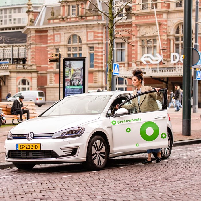 Greenwheels en de NS openbaar vervoer jonge vrouw bij NS station Holland Spoor