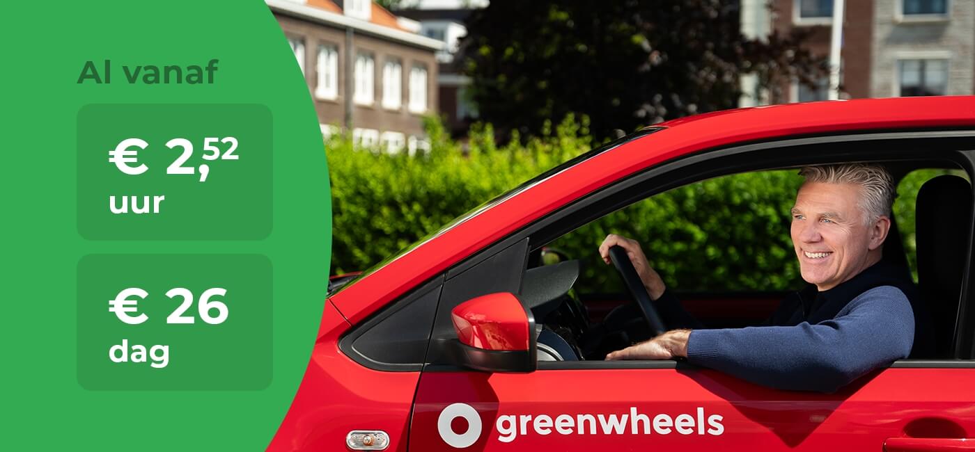 Man in Greenwheels-auto met prijzen - mobiel
