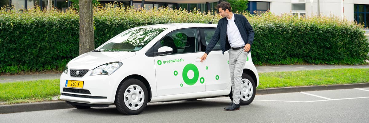 Man opent elektrische Greenwheels deelauto