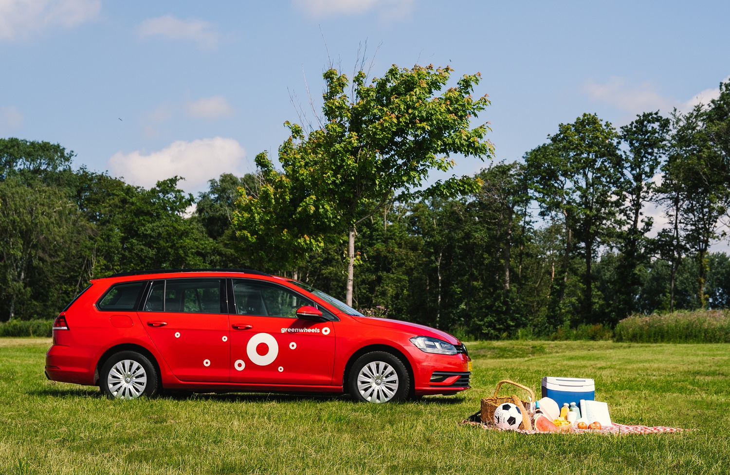 Deelauto van Greenwheels op grasveld met picknickmand zomers uitje of vakantie