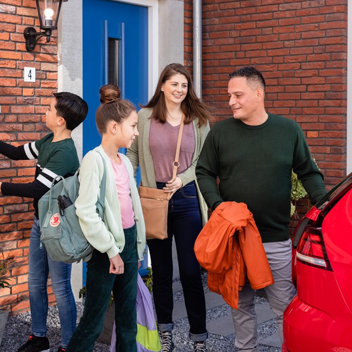 Gezin bij rode Greenwheels deelauto