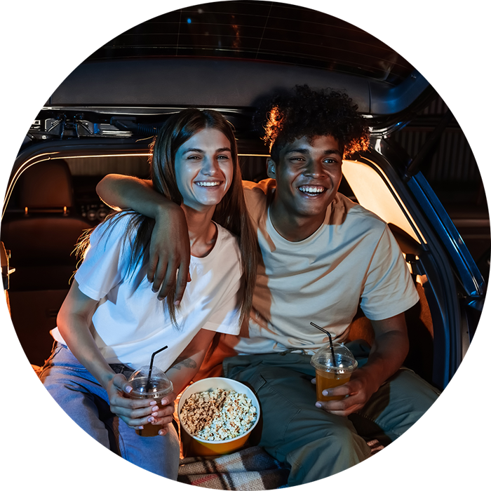 Koppel in auto bij drive-in bioscoop met popcorn en drinken