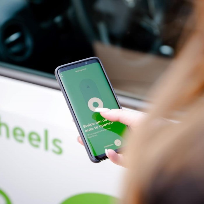 Persoon opent deelauto en start de rit met Greenwheels app