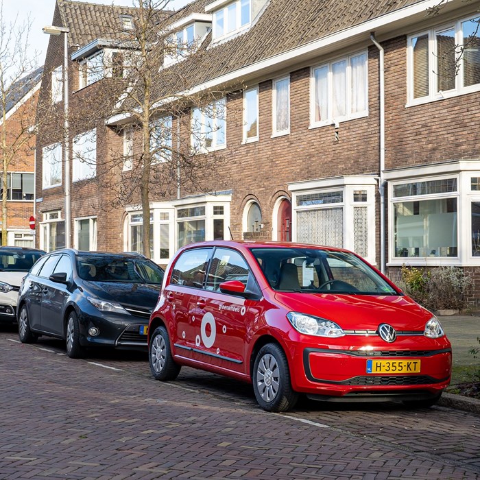Greenwheels auto geparkeerd voor de deur in een woonwijk